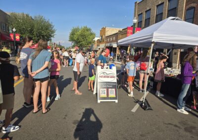 Pro Motors Service sandwich board sign at a Zeeland community street event.
