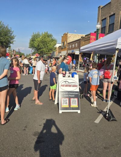Pro Motors Service sandwich board sign at a Zeeland community street event.