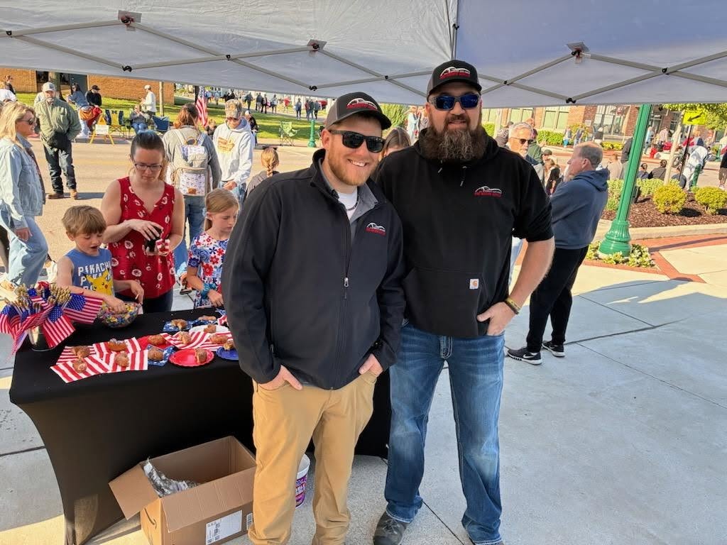 Two Pro Motors Service team members at a Memorial Day community event.